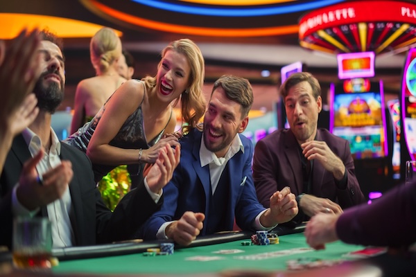 A group of attractive people laughing at a casino table